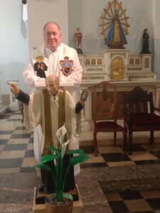 El Padre Lafferty, junto a la imagen que recuerda al creador de la Congregación Palotina, San Vicente Pallotti.